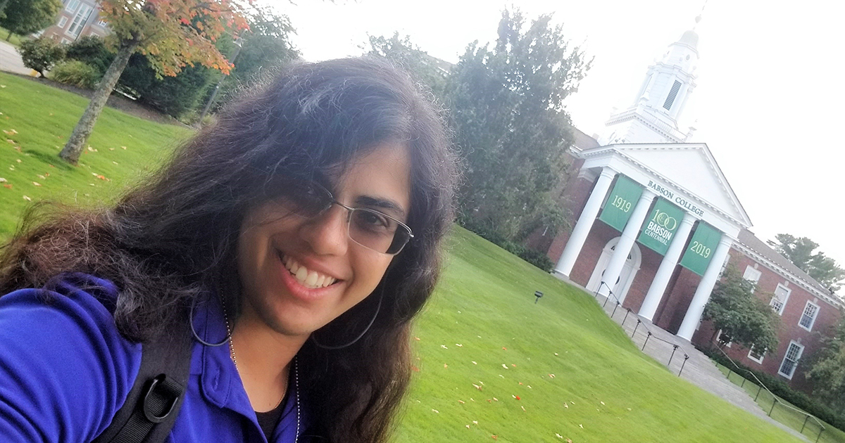 Saadia Ahmad poses in front of Tomasso Hall on the Babson campus