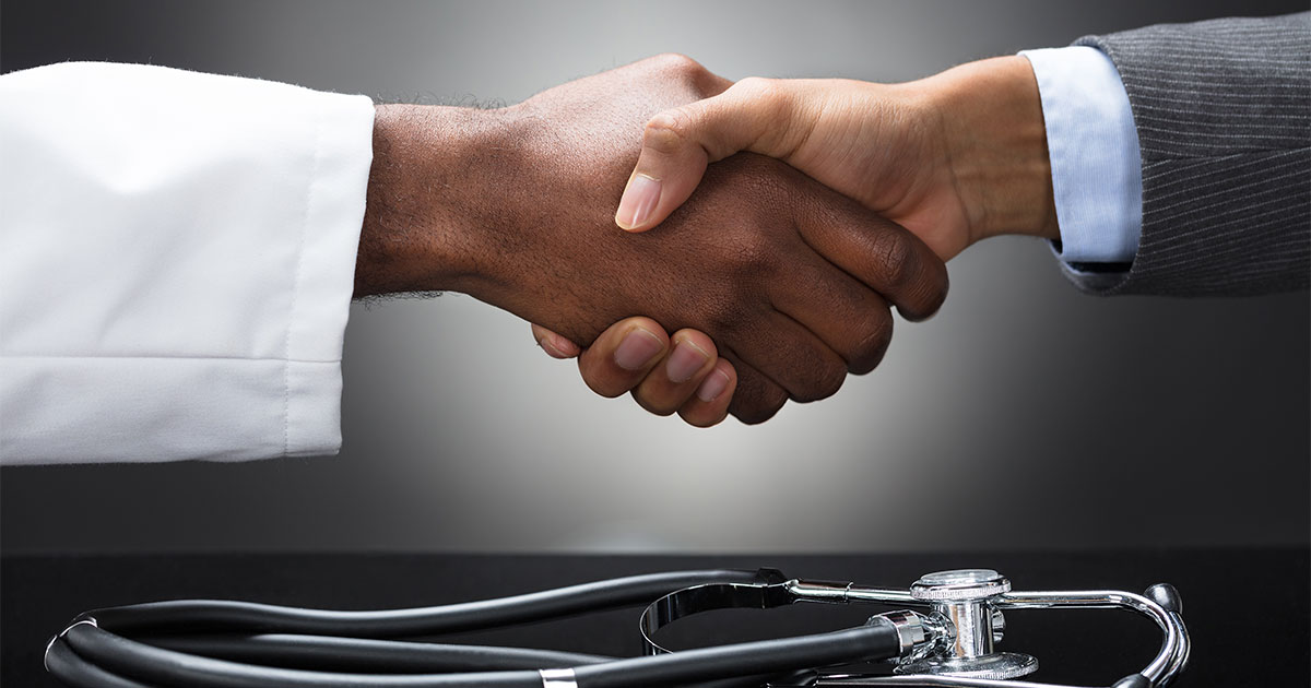 Two hands shaking to form a medical partnership