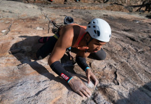 Kai Lightner '22 climbs up a rock face.