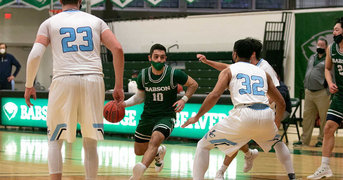 Babson basketball player Teddy Sourlis ’22 drives down the court against defenders