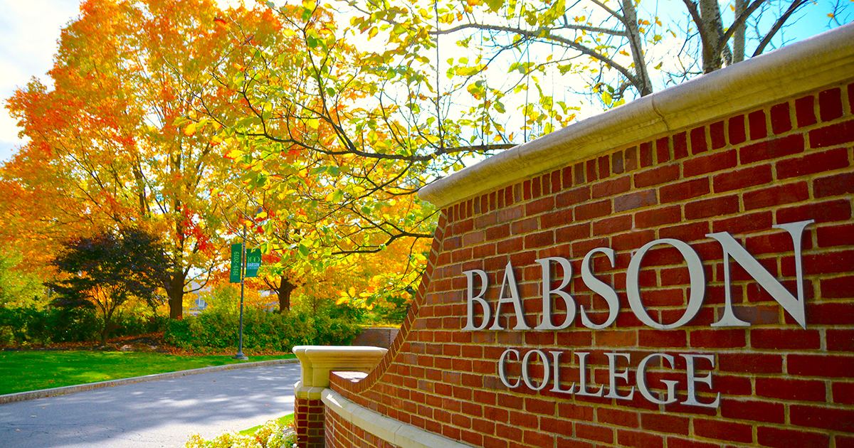 Closeup of the Babson front gate with fall foliage in the background