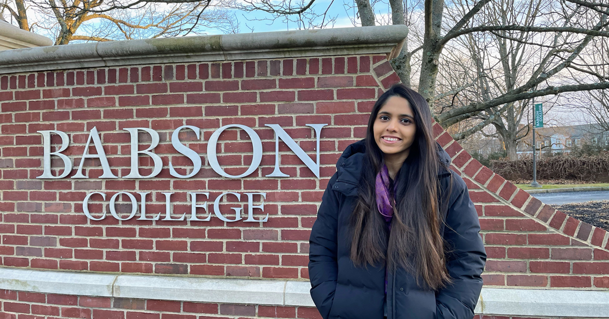 Preshika Jain poses for a photo at the Babson College front gate