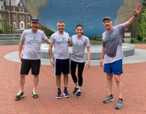 Babson employees in front of the Babson World Globe after a run