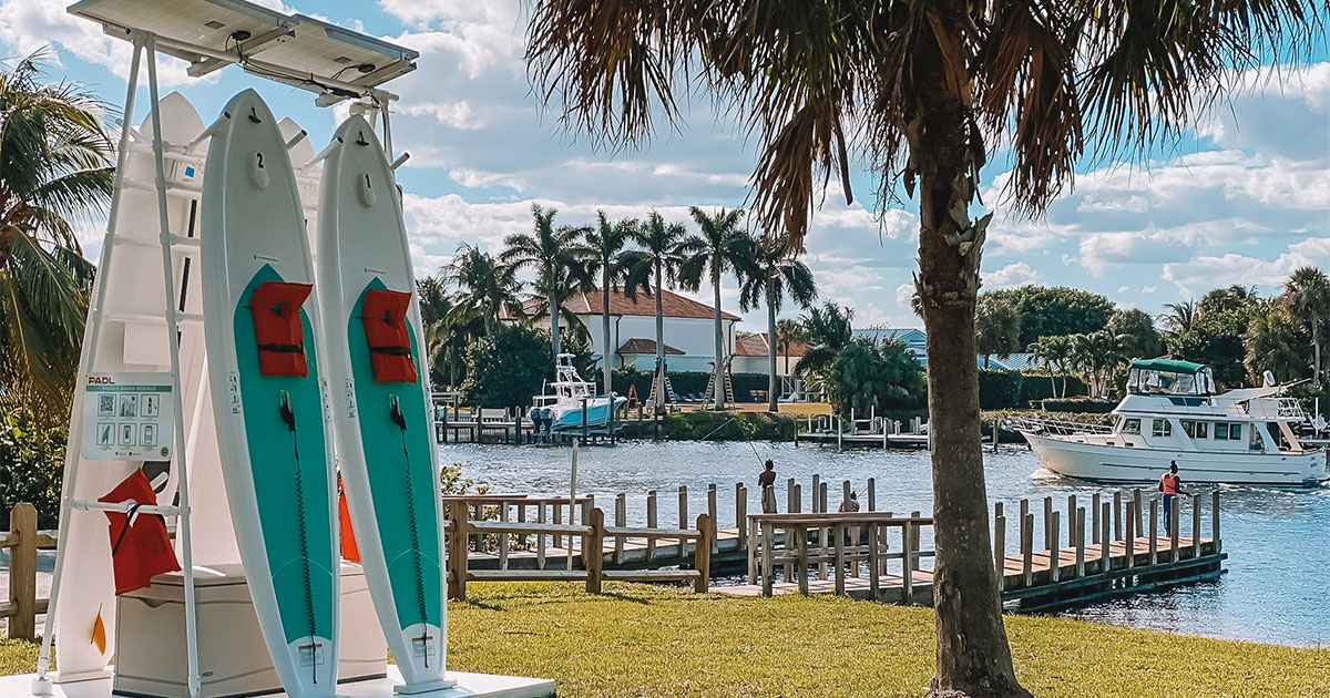 A PADL station with paddleboards for rent rests near a dock in Florida