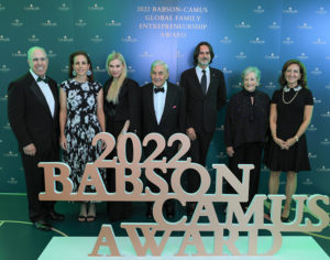 Award event attendees stand in front of 2022 Babson Camus Award sign