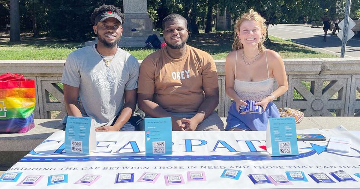 Aaron Bart-Addison, Sedonami Agosa ’20, and Anna Gildea, the three leaders of ClearPath, sit at a table filled with information about their nonprofit.