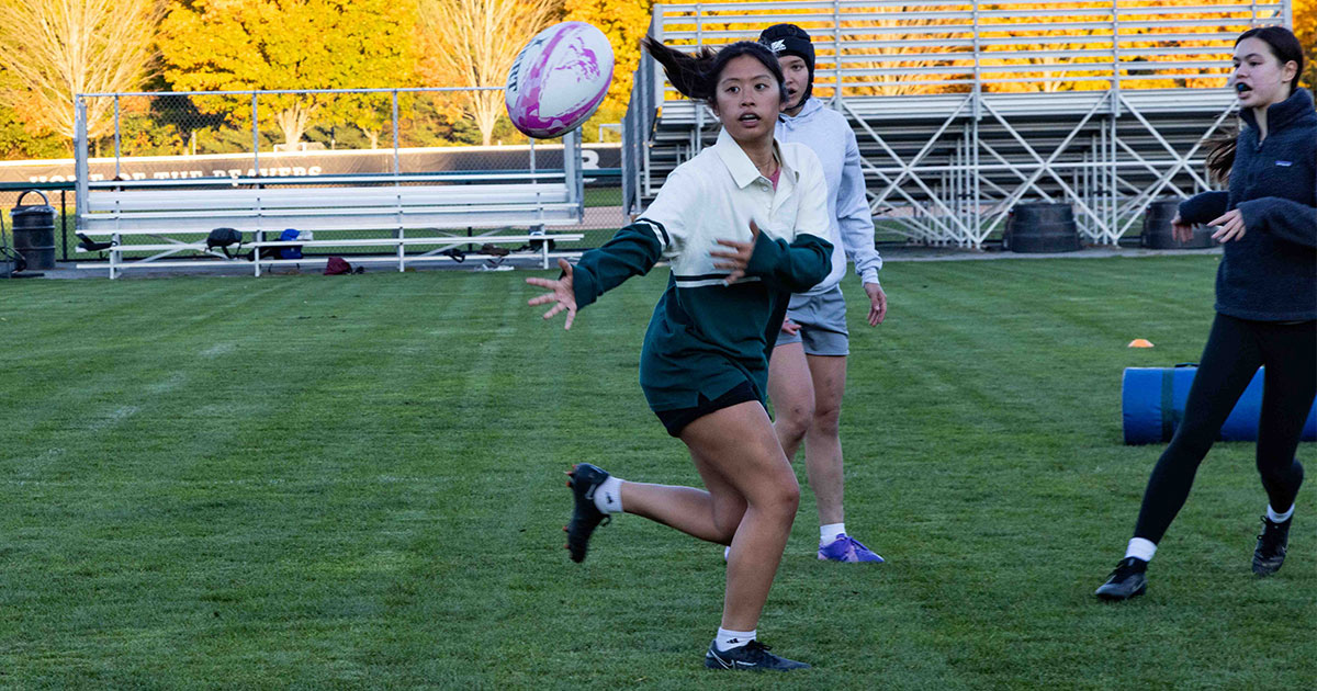 Three members of the Babson Women’s Rugby Club practice at the Harrington Rugby Pitch