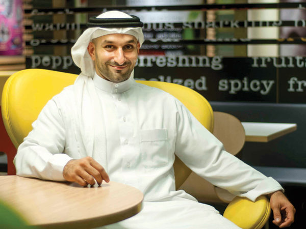 Abdulla Adel Fakhro smiles while sitting at a table