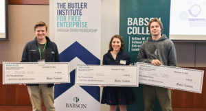 Three students hold large prize checks