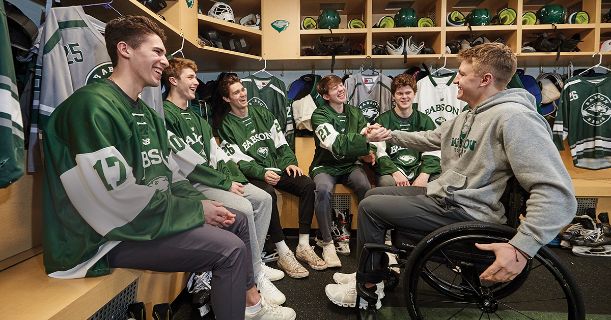 Jake Thibeault greets five of his hockey teammates in the Babson dressing room