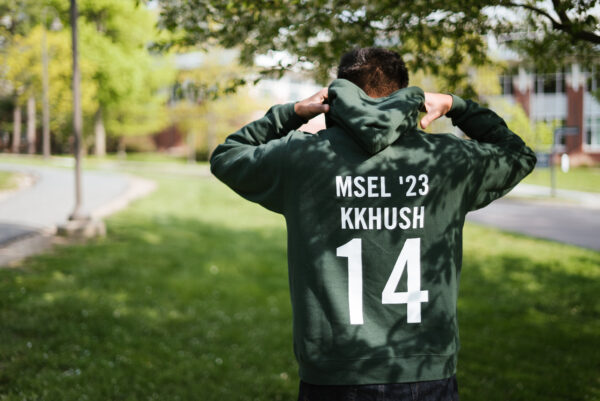 Kkhush Aggarwal shows the back of his sweatshirt that reads, "MSEL'23 KKHUSH" with a large number 14.