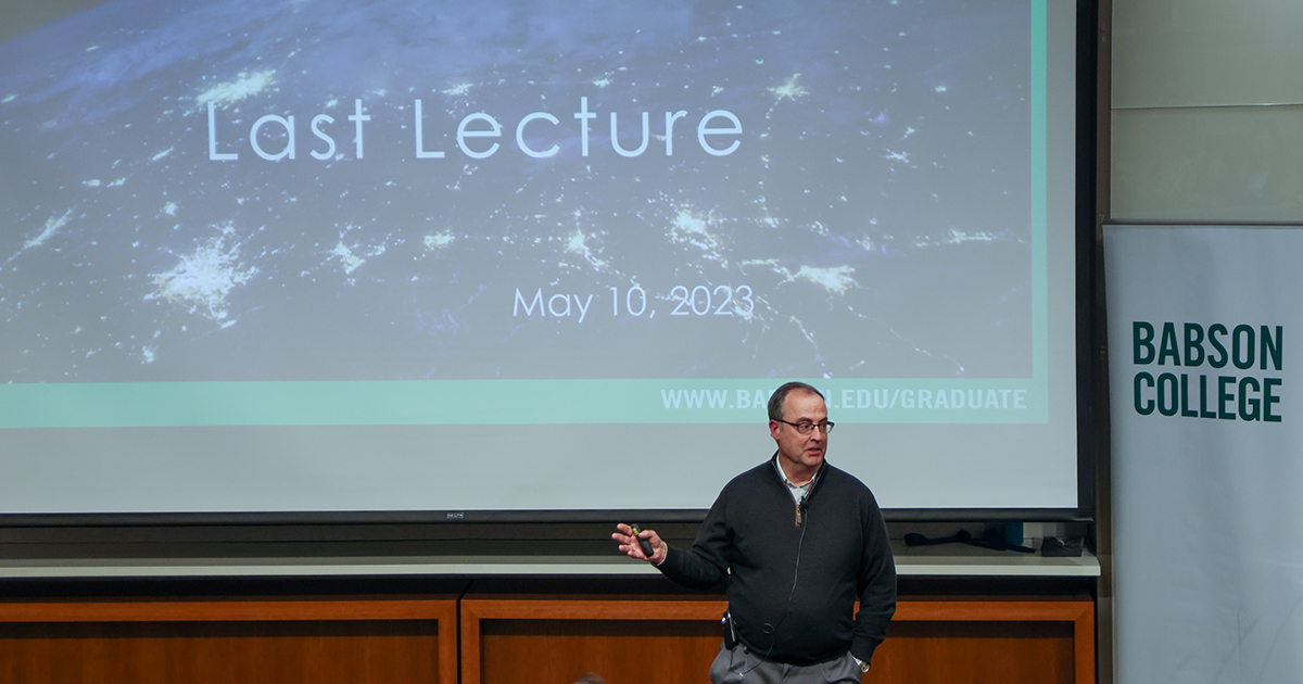 Richard Goulding speaks in front of a large screen that reads, "Last Lecture"