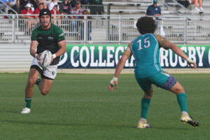 Reed Santos runs with the ball during a rugby match at the national tournament.