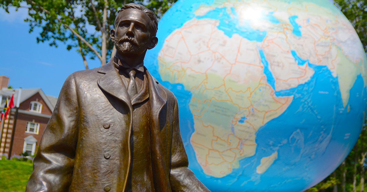 The Roger Babson statue stands with the Babson World Globe behind it