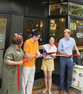 Joy Yongjing Zhu cuts the ribbon to open her restaurant