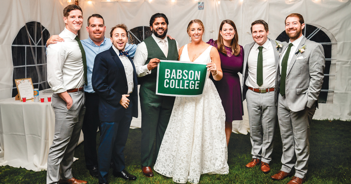 A group of alumni pose for a wedding photo