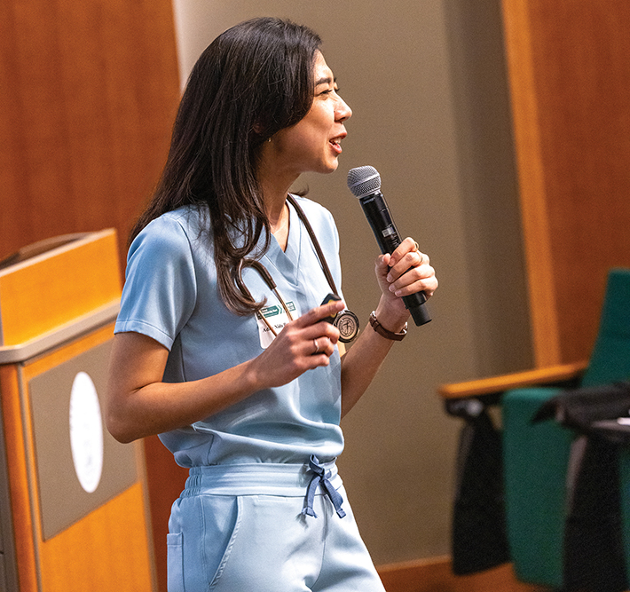 Woman speaks into a microphone during her pitch