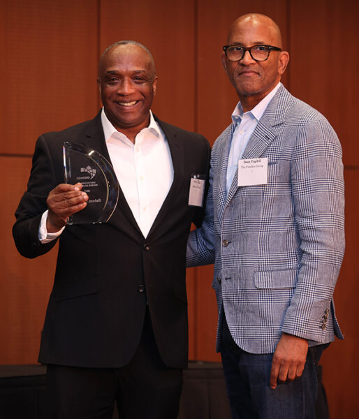 Jerry Epps holds the awards while posing for a photo with Sean Cogdell