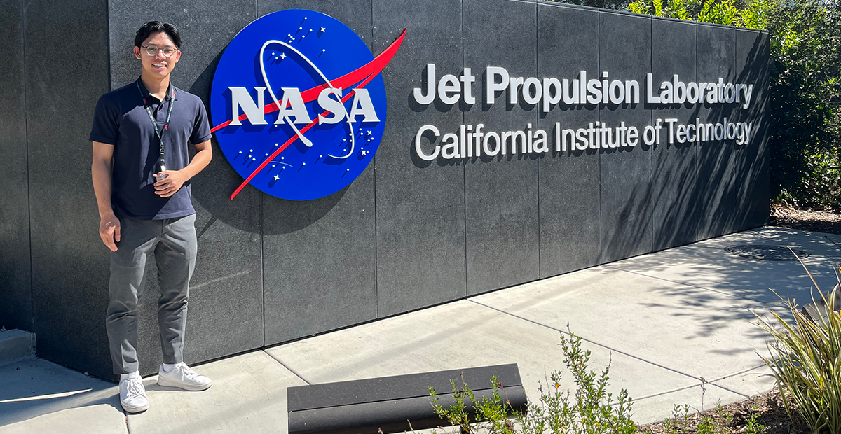 Joshua Kim in front of a sign for NASA's Jet Propulsion Laboratory at California Institute of Technology.