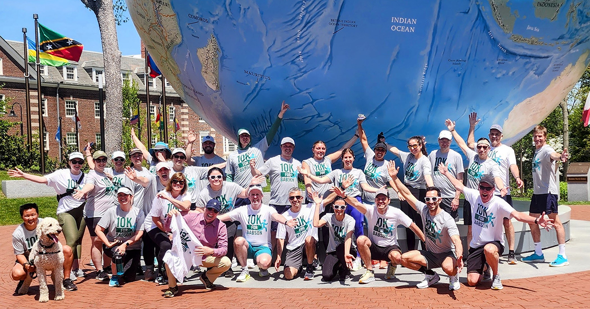 The runners pose for a group photo in front of the Babson World Globe