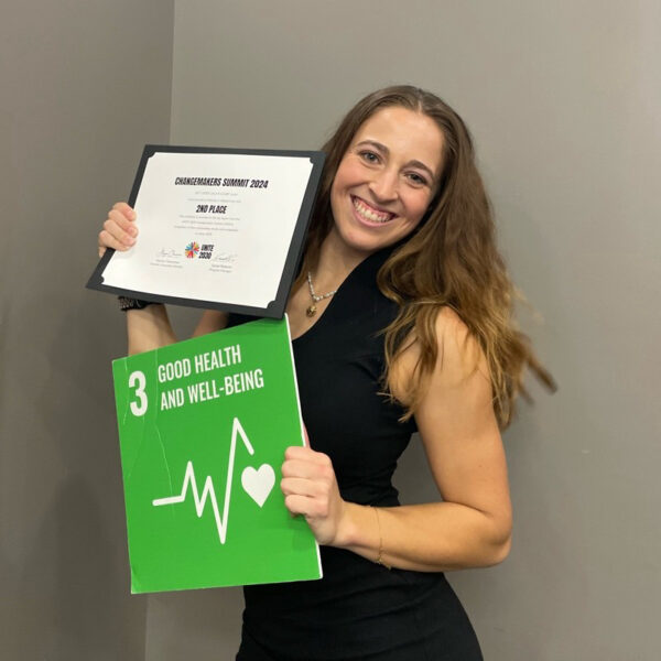 Kaitlyn Pristawa smiles with her award and the UN SDG