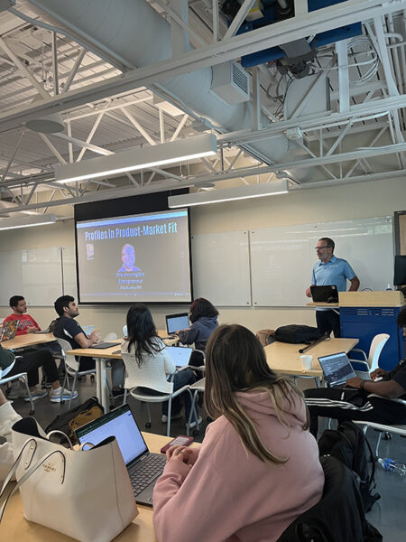 Overview of a classroom with a speaker presenting to students