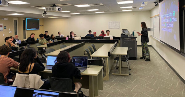 Classroom of students listen to a speaker at the front of the class