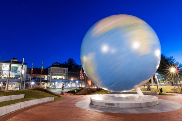 The Babson World Globe in front of a brilliant blue sky at night