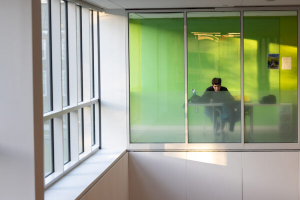 A student sits at a table in a study room