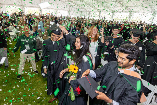 Graduate students celebrate their Commencement amid confetti