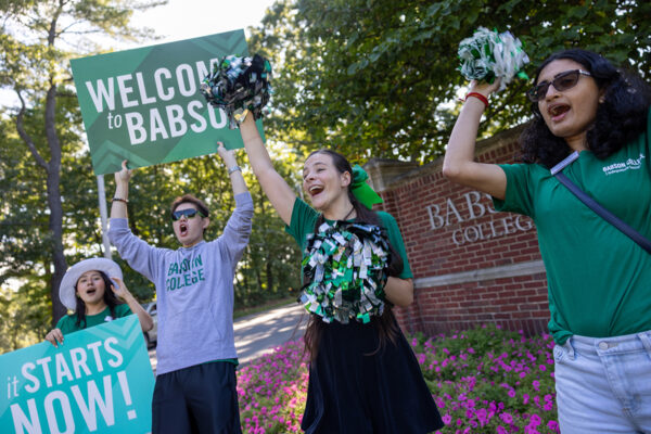 Students greet arrivals at the front gate on move-in day