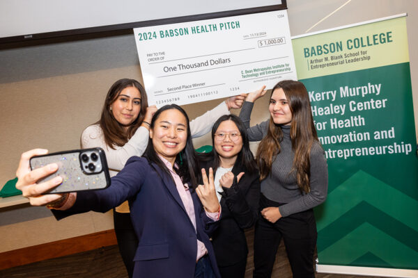 Students pose for a selfie with their winning check at the KMH Health Pitch