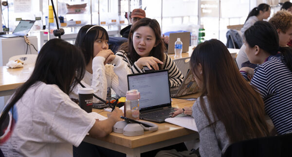 Students discuss their concepts around a table