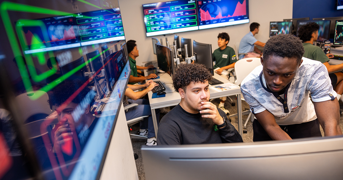 College students look at computer screen during a financial investment class.
