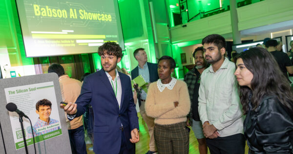 A student motions while speaking at his exhibit