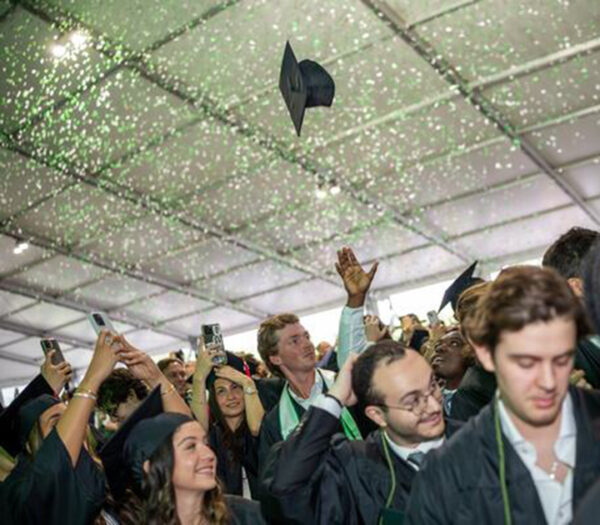 Confetti surrounds celebrating college graduates.
