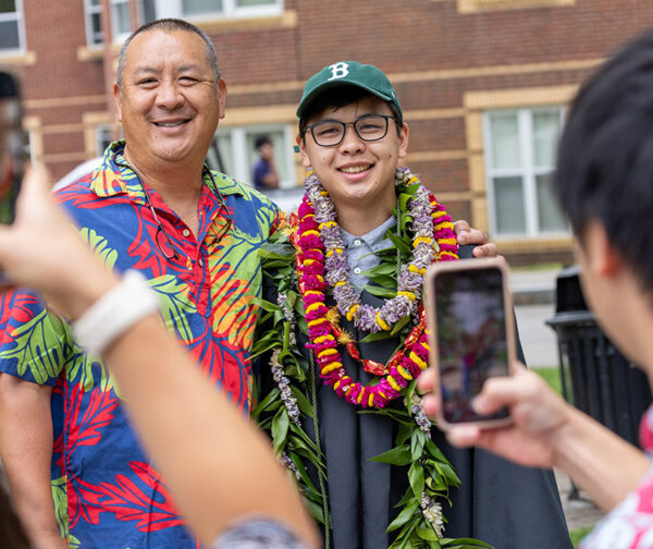 College graduate stands with family for photos.
