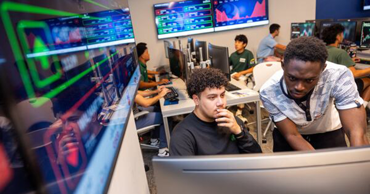 College students look at computer screen during a financial investment class.