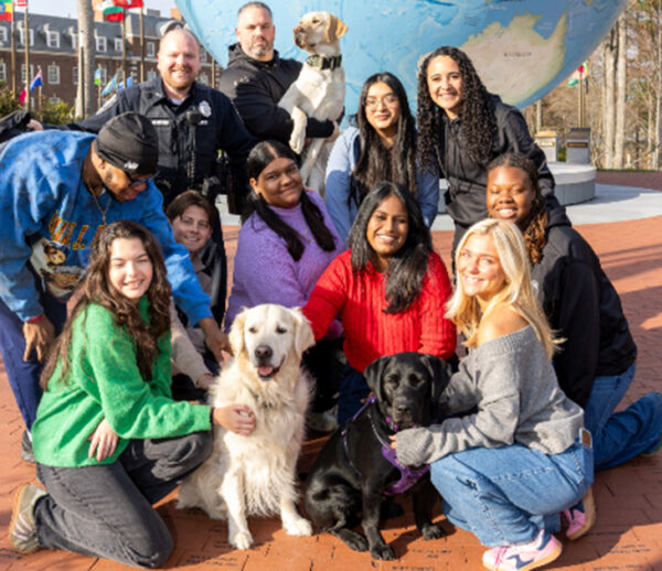 A group of people pose with Babson's three community resource dogs.