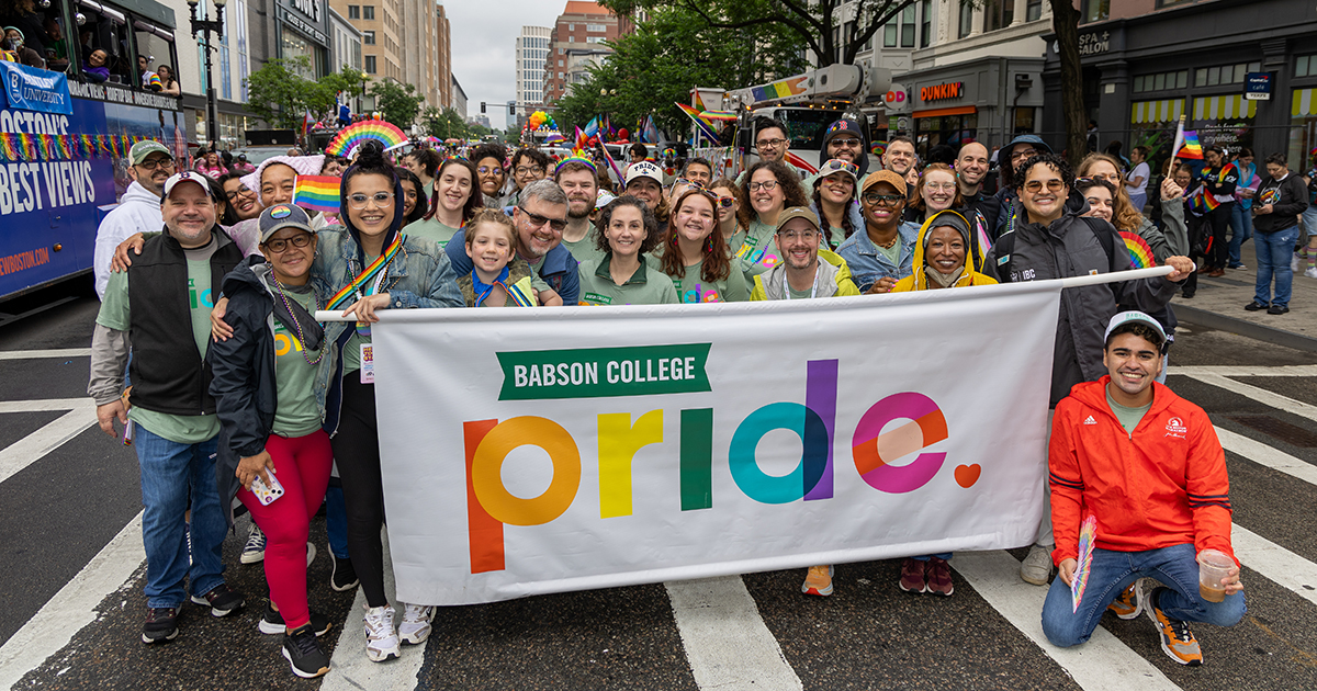 Members of the Babson community behind a Pride banner at the parade