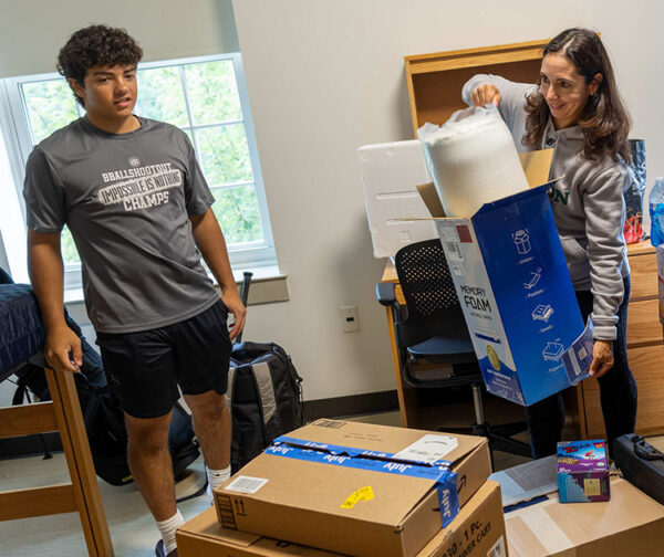 A mother and son unpack at college.
