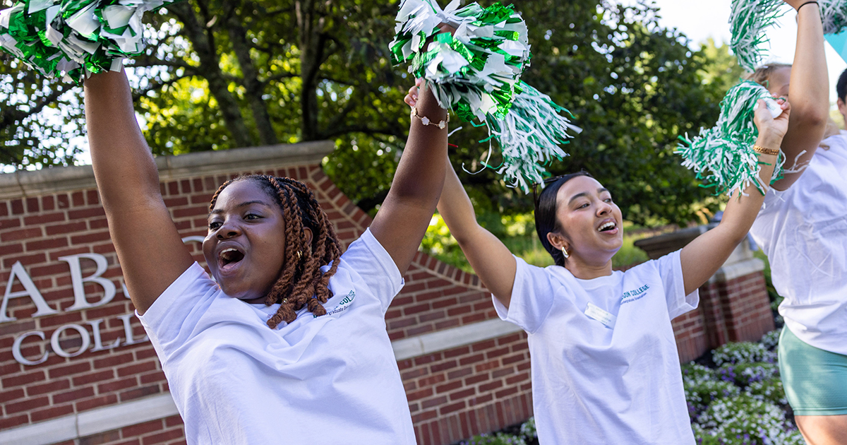 Two students cheer with pompoms during move-in day