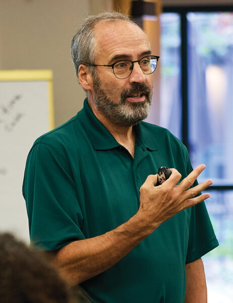 Andrew Zacharakis motions while speaking in a classroom