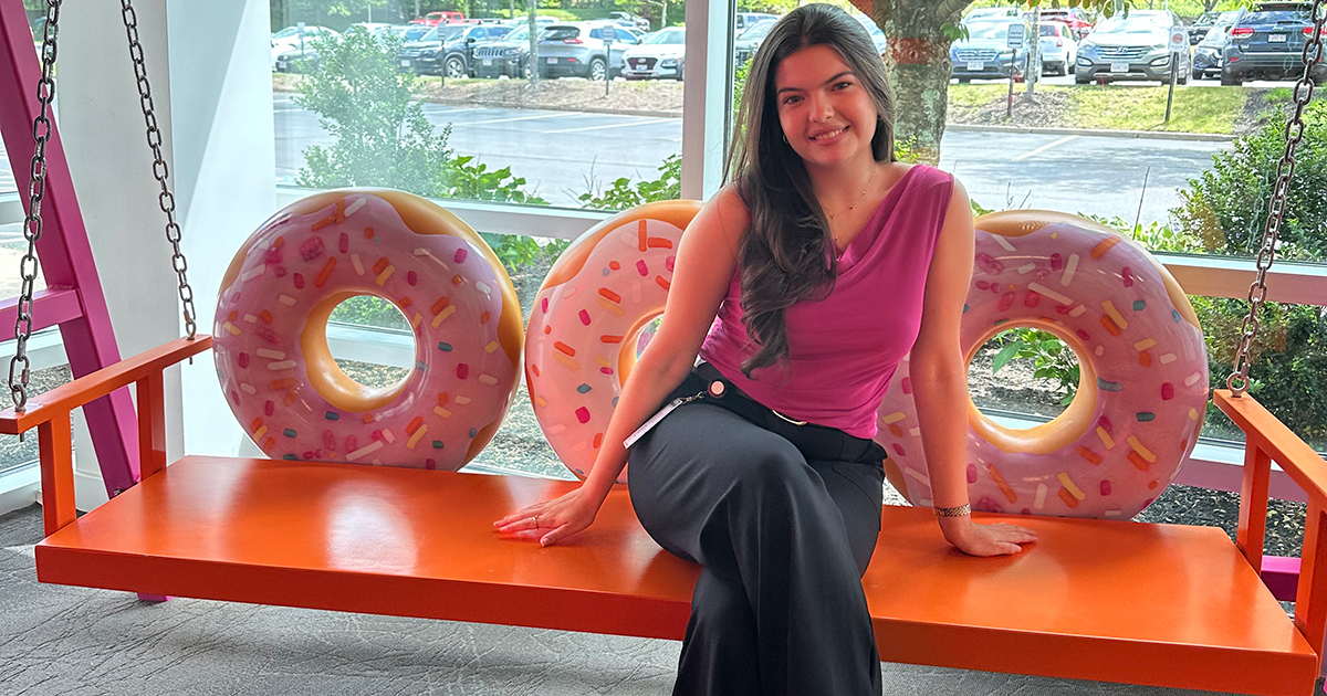 Luciana Gomez ’27 sitting on a bench shaped like donuts