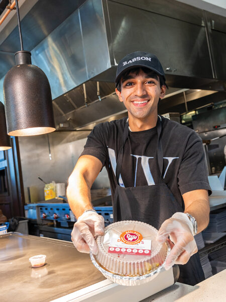 Krish Khemlani serves a takeout container order at Roger's Pub