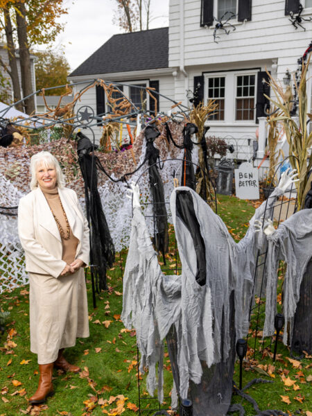 Sharon Sinnott poses for a photo outside her home amid the trappings of her haunted trail