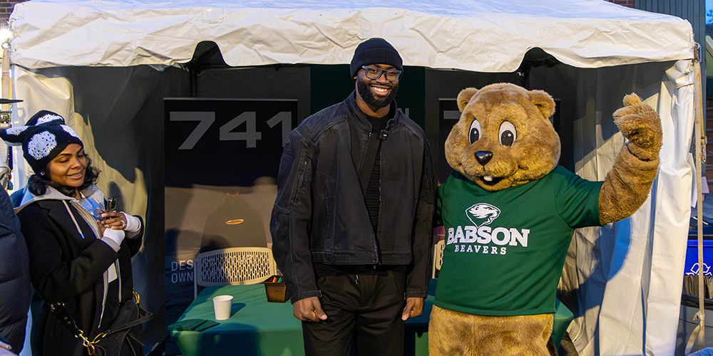 Jaylen Brown and Biz E. Beaver pose for a photo in front of a tent on campus