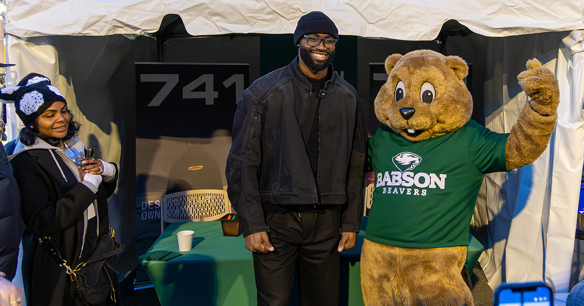 Jaylen Brown and Biz E. Beaver pose for a photo in front of a tent on campus
