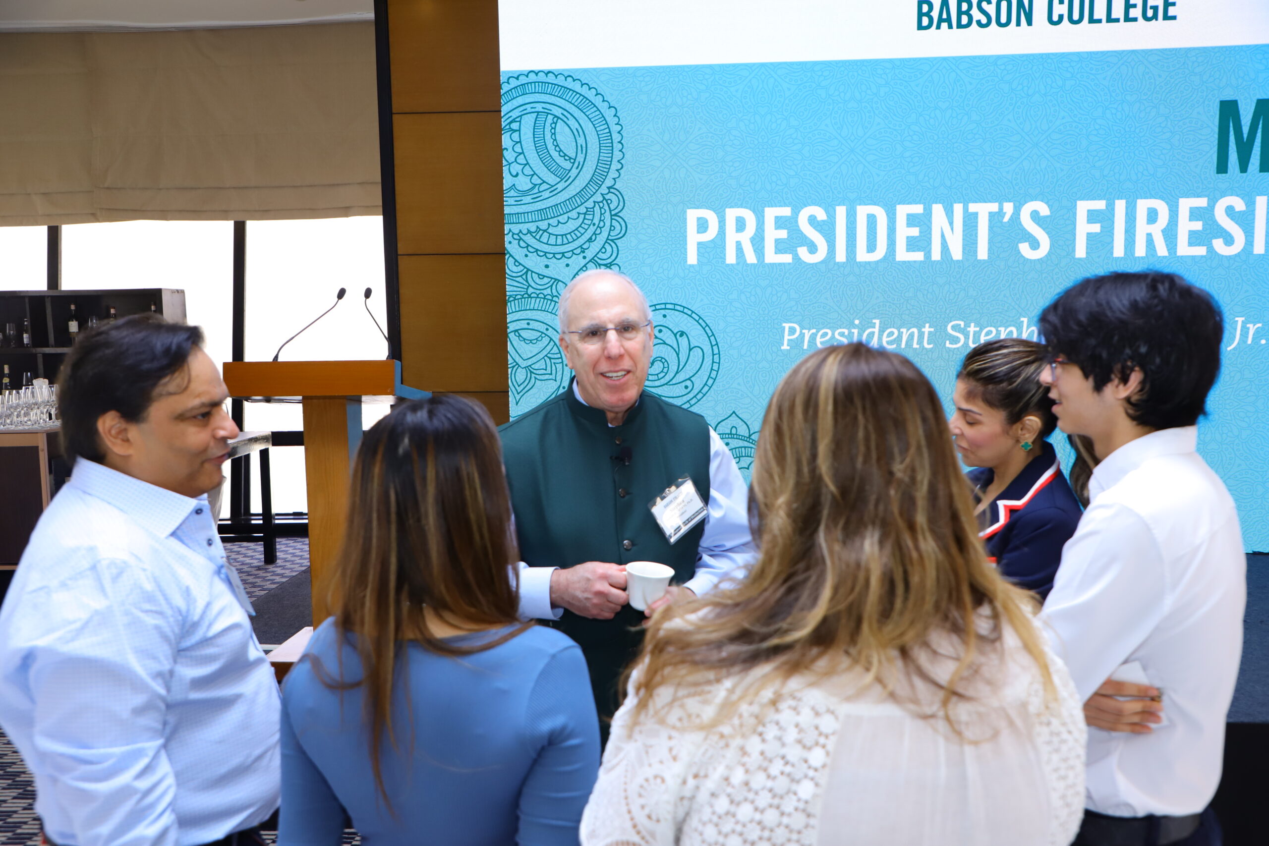 President Spinelli speaking with a group of alumni.