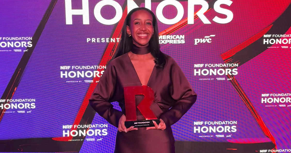Babson student on stage after winning $25,000 scholarship.